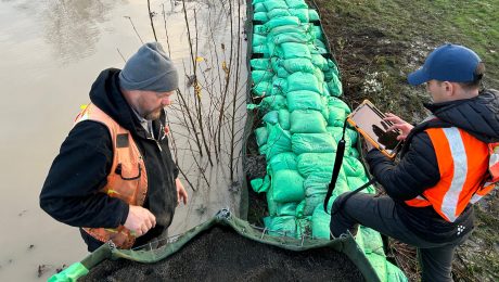 A photograph showing King County emergency management personnel assessing a levee.